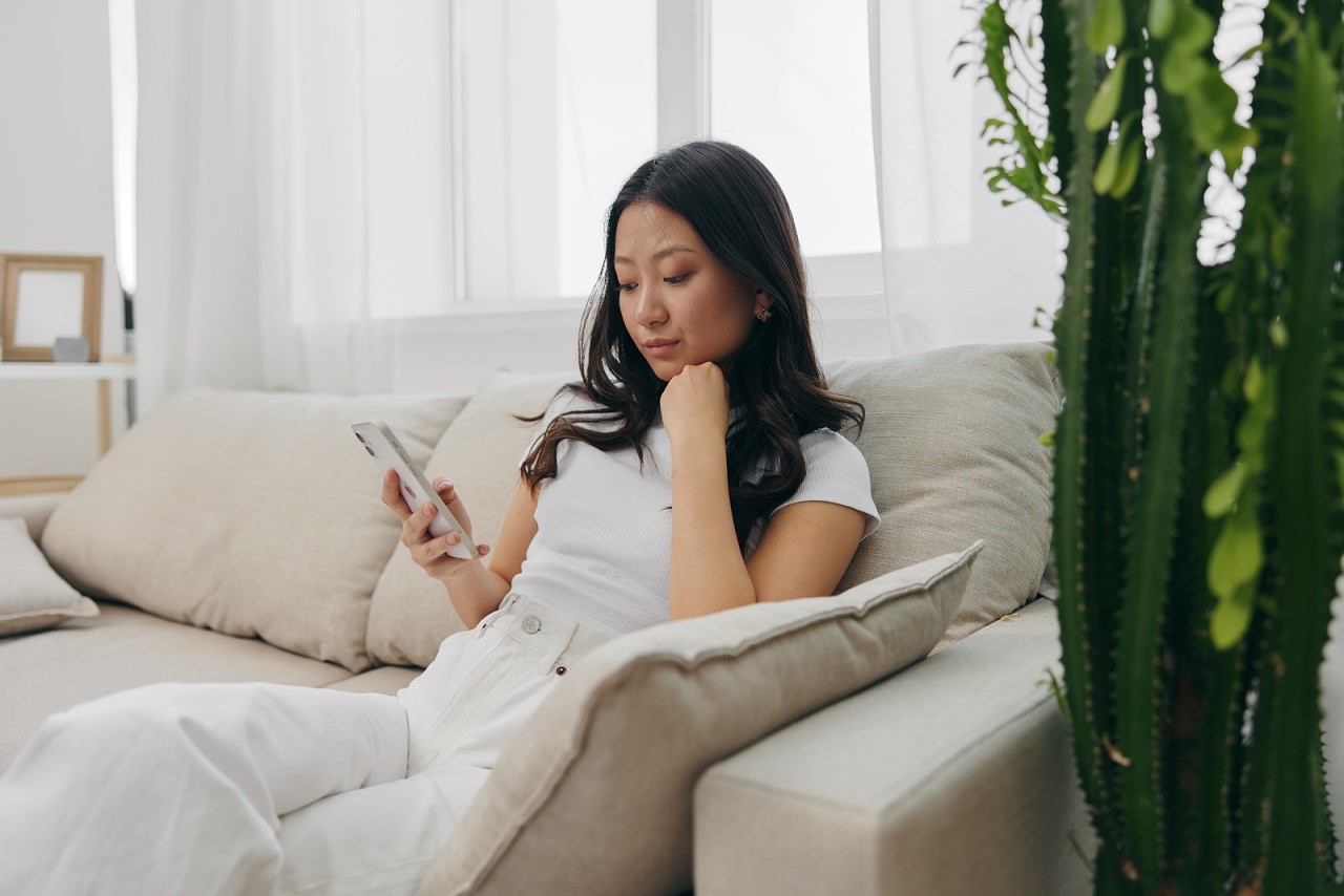 bigstock-A-Young-Asian-Woman-Sits-At-Ho-460886705