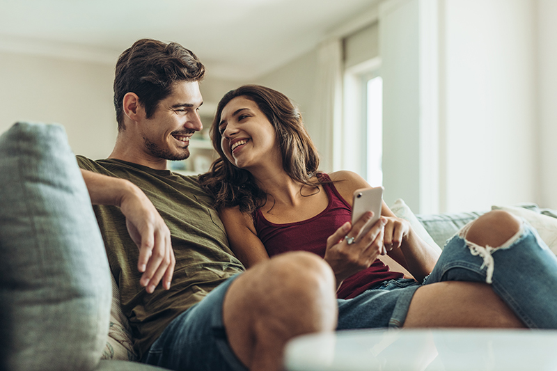 Young couple sitting on the couch together